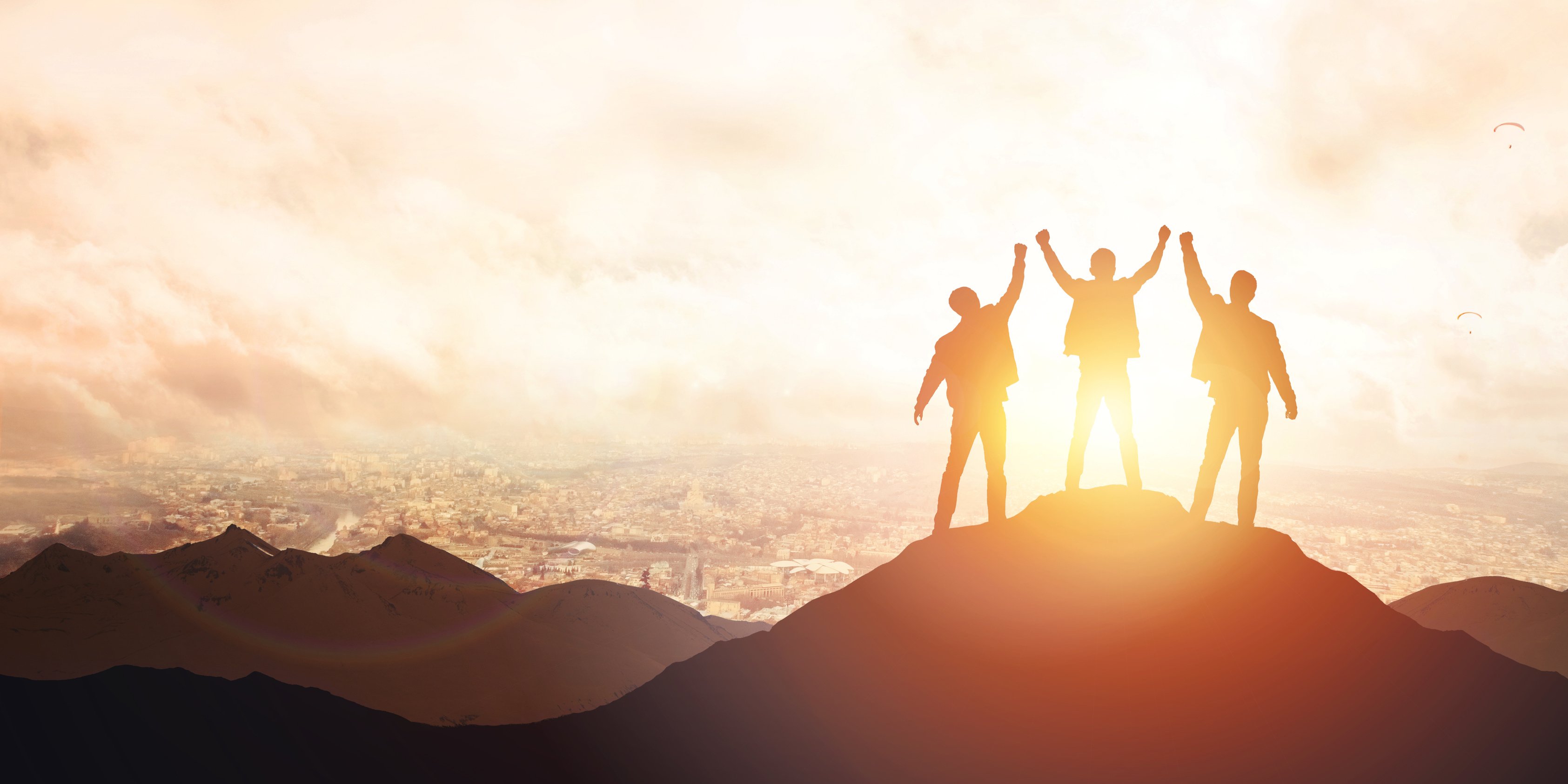 Silhouette of the team on the peak of mountain