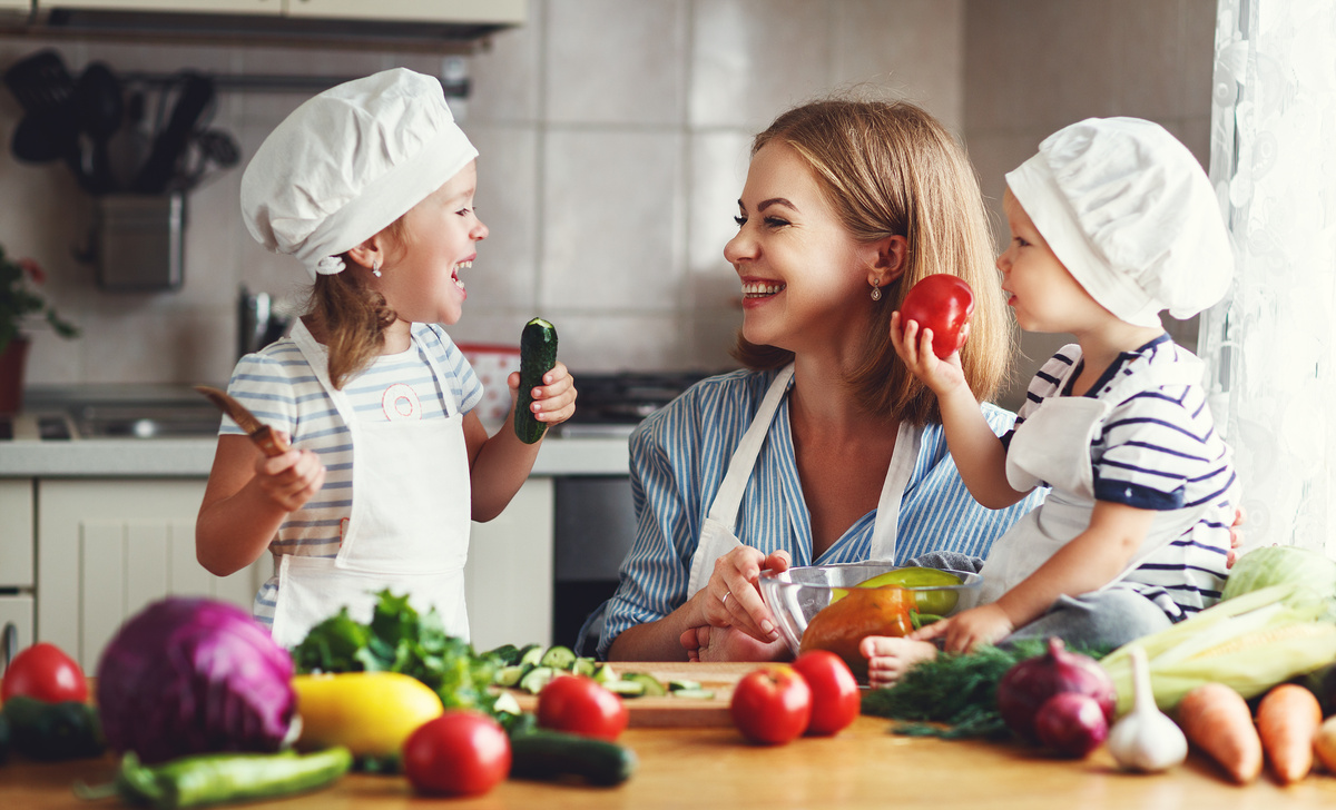 Healthy eating. Happy family mother and children prepares  vegetable salad